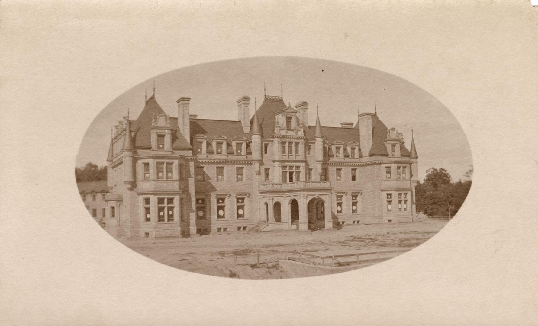 Sepia toned photograph of large multi-storied mansion.