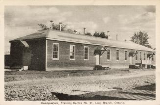Sepia-toned photo postcard depicting a bungalow with several doors, at a Canadian Army Training ...