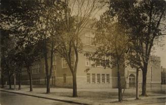 Black and white photograph of a three story collegiate building.