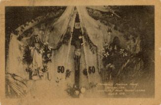 Black and white photograph of decorations in a church with statuary.