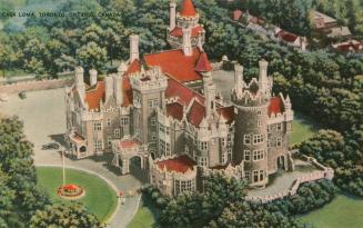 Color, aerial photograph of a castle surrounded by trees.