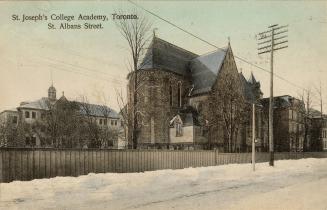 Colorized photograph of a gothic revival style church with surrounding buildings. Snow of the g ...