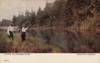 Colorized photograph of two women standing on the bank of a river fishing. One has caught a lar ...