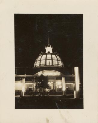 A photograph of a one story building with a dome partially constructed of glass. The photo is t ...