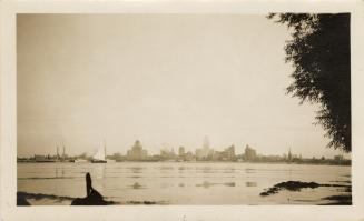 A photograph of a city skyline, with many tall buildings and skyscrapers visible on the far sid ...