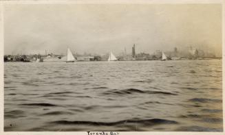A photograph of a city skyline, taken from across or on a large body of water. Buildings and sm ...