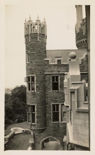 A photograph of a stone castle-like building, taken from a vantage point on a different part of ...