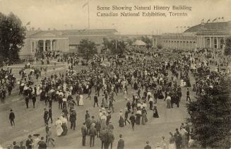 Black and white photograph of crowds of people standing in front of a huge, classical arenas.