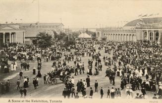 Black and white photograph of crowds of people standing in front of a huge, classical arenas.