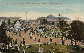 Colorized photograph of crowds of people waling on roads and lawns in front of large arenas.