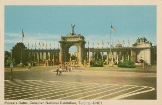 Color photograph of a large, neoclassical archway made of cement and stone. People are walking  ...