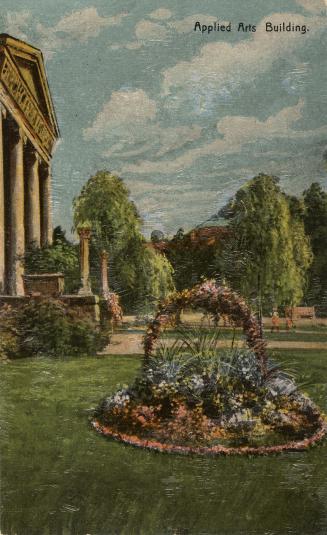 Colorized photograph of a circular flower bed in a lawn outside a classical style building with…