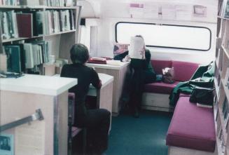 Interior of bookmobile with two people seated.