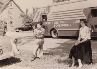 Picture of man and woman sitting in front of bookmobile. 