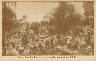 Sepia toned photograph of a crowd of people on the lawn in front of a large Beaux Arts building ...