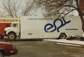 Picture of a large white bookmobile with blue lettering. 