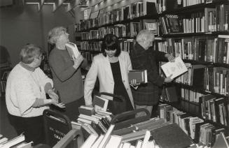 Picture of group of people shelving library books.