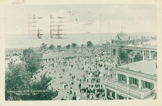 Black and white photograph of exhibition buildings set on vast acres of grounds with huge crowd ...