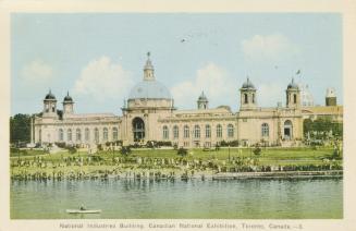 Colorized photograph of a Beaux-Arts building with turrets. A body of water is in front of it.