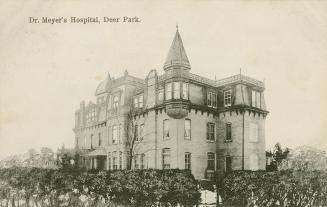 Black and white photograph of a large hospital building with a turret.