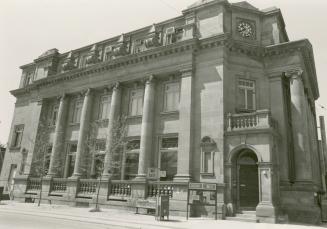 Picture of large stone library with pillars and corner entrance. 