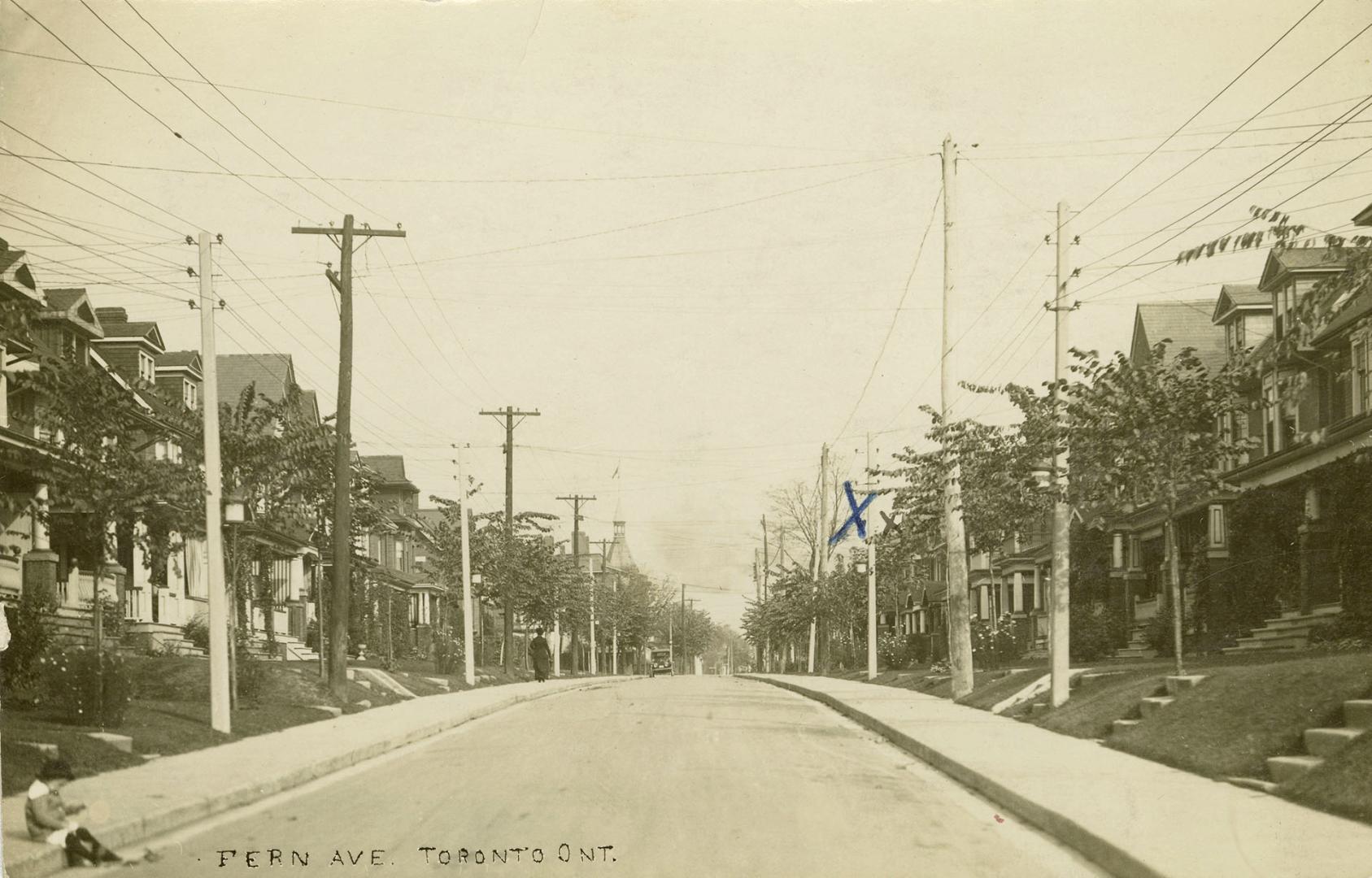 Black and white photograph of two-story houses lining a street.