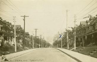 Black and white photograph of two-story houses lining a street.
