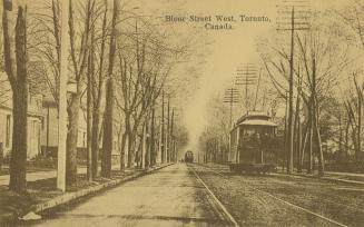 Sepia toned photograph of a streetcar and an automobile running along a city street with large  ...