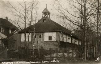 Black and white photograph of a one story church building with a bell tower.