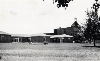 Black and white photograph of several one story, public buildings.