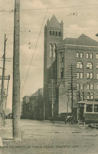 Black and white photo postcard depicting Front St. W. and Union Depot, with a streetcar and hor ...