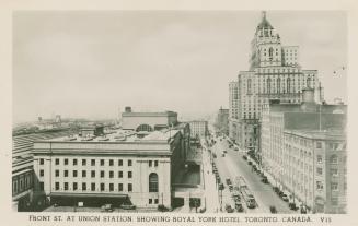Black and white photo postcard depicting a view of Front Street looking west, with Union statio ...