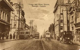 Sepia toned photograph of cars, buggies and streetcars on a busy city street.