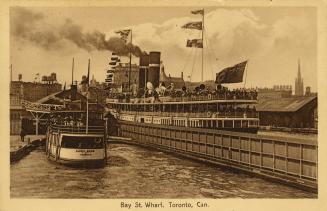Sepia toned photograph of steam boats moored at busy, city docks.