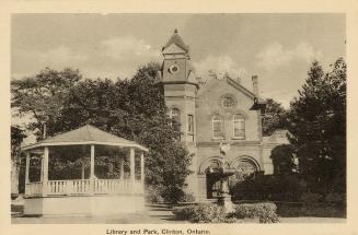 Picture of a library building with tower on the left and park bandstand to the front. 