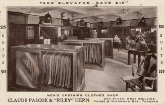 Black and white photograph of the interior of a shop which sells suits for gentlemen.