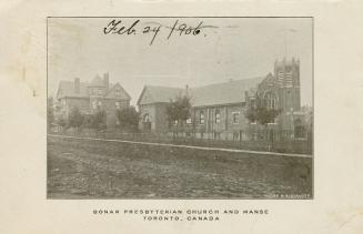 Black and white photograph of a large brick church and matching manse.