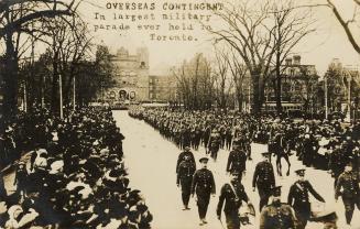 Black and white picture of soldiers marching on an icy city street while crowds of civilians lo ...