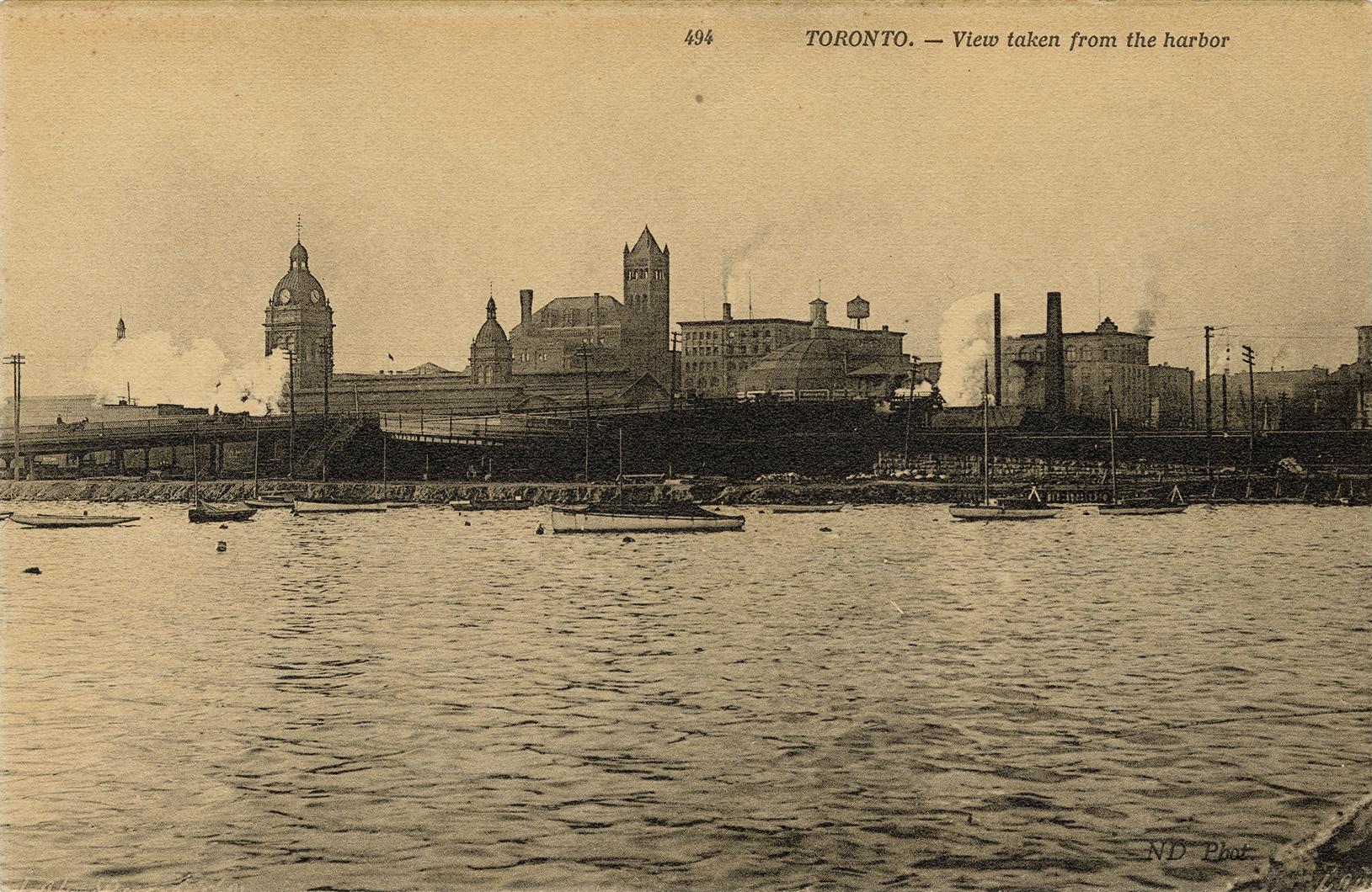 Sepia-toned photo postcard depicting the Toronto harbor with views of Union station and towers  ...