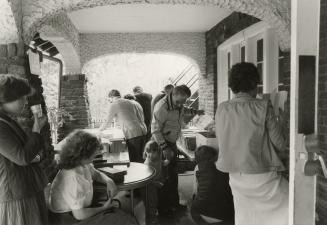 Picture of people at a book sale on porch of library. 