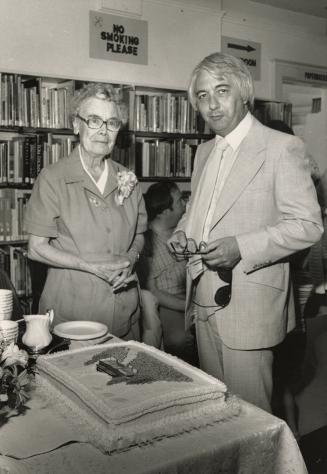 Picture of man and woman at a table with a cake