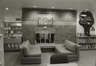 Picture of interior of library showing fireplace and couches. 