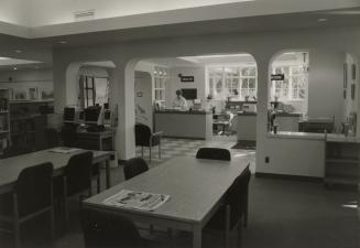 Picture of interior of library showing front desk and tables. 