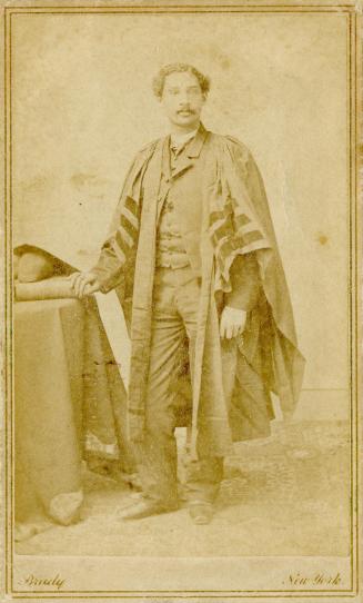 Black and white photograph of Anderson Ruffin Abbott standing, in academic robes