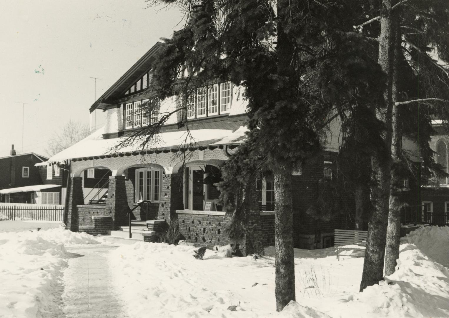 Picture of an arts and craft style house with lawn covered in snow. 