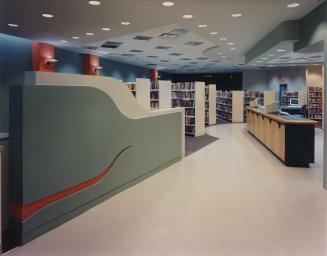 Picture of interior of library showing check out desk and shelving. 