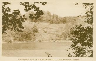Sepia toned picture of a view of a waterway, with a rocky outcrop beside it.