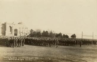 Black and white photograph of lines of servicemen in front of very large buildings.