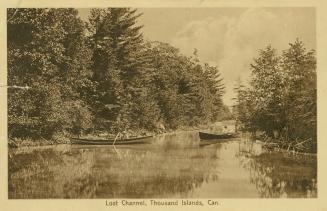  Sepia toned photograph of people in row boats on a river surrounded by trees.