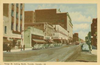 Colour photo postcard depicting a view of Yonge Street looking north from Gerrard with cars par…